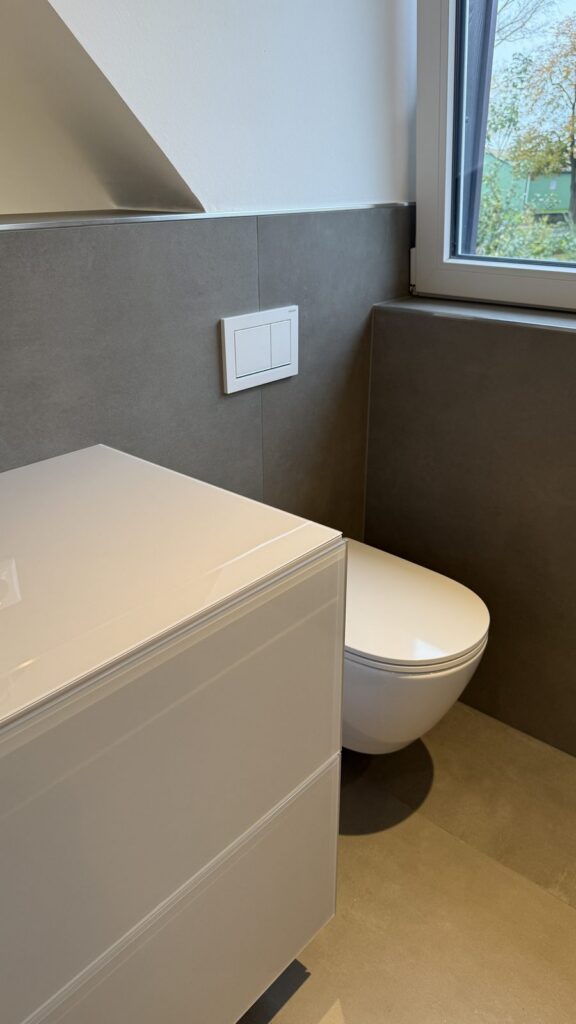 Von der Höft GmbH saniertes Badezimmer mit großformatigen Fliesen, Wand-WC und schwebendem Waschtischunterschrank