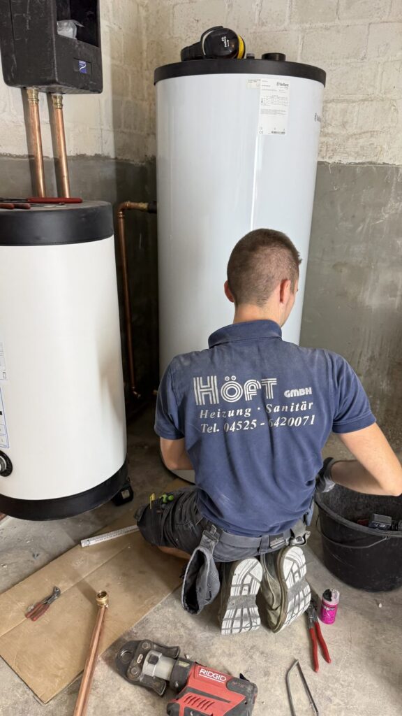 Monteur der Höft GmbH bei der Montage an Pufferspeicher und Warmwasserspeicher